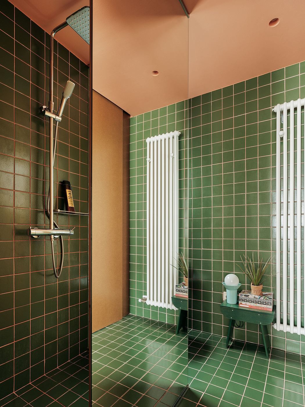 Modernist bathroom with green tile walls, white radiator, and stylish decor.