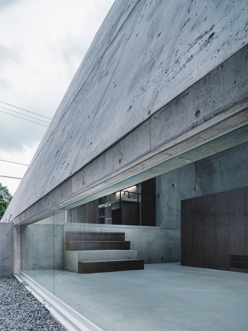 Dramatic concrete architecture with angular exterior and minimalist interior.