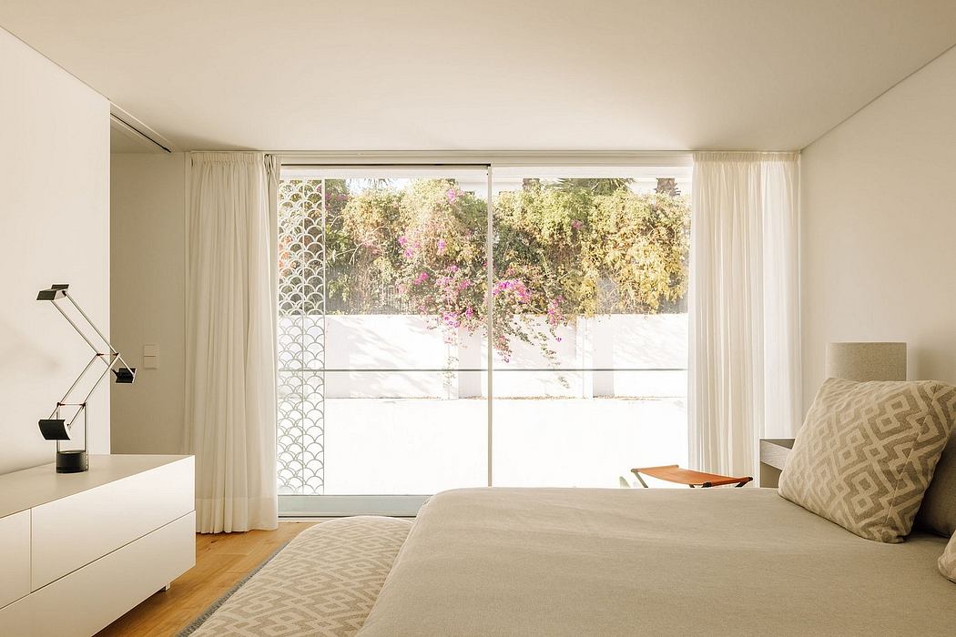 Spacious bedroom with large windows overlooking a lush, blooming garden.