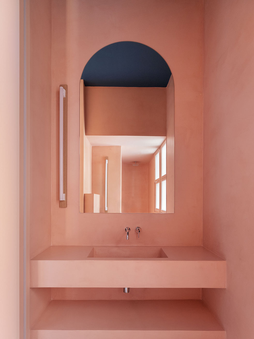 Minimalist bathroom design with arched mirror, floating vanity, and neutral tones.