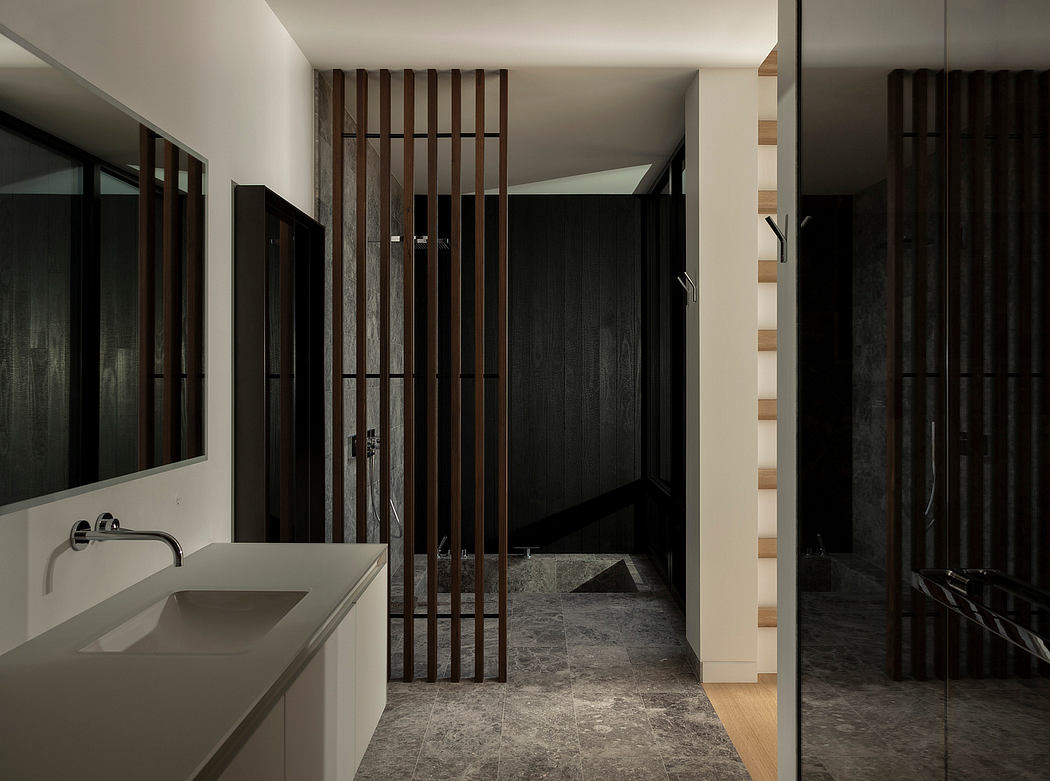 A modern, minimalist bathroom with sleek dark wood accents and natural stone tile flooring.