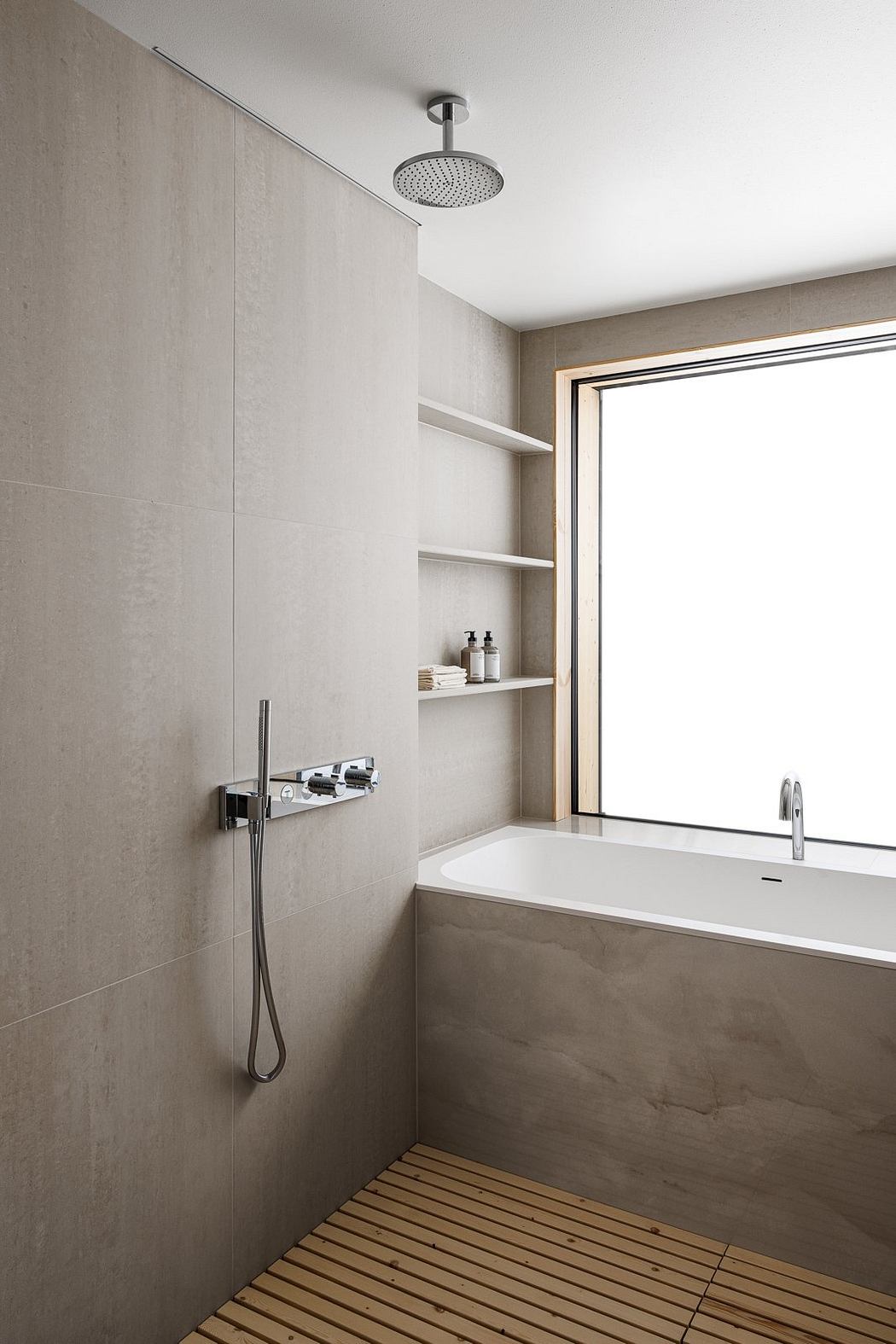 Modern bathroom with large shower head and built-in shelves. Minimalist design with natural materials.