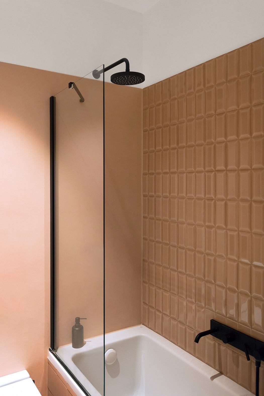 Modern bathroom with textured, copper-colored tiled wall and black shower fixtures.