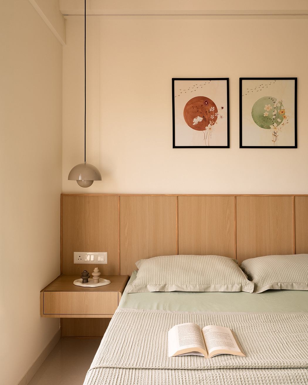 Cozy bedroom with warm wood tones, minimalist decor, and framed abstract art.