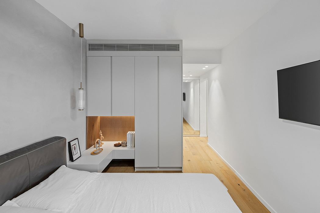 Minimalist bedroom design with built-in wardrobe, lighting, and modern decor elements.