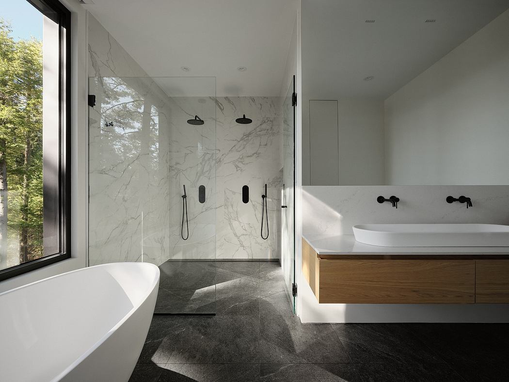 Spacious, modern bathroom with marble walls, freestanding tub, and floating wood vanity.