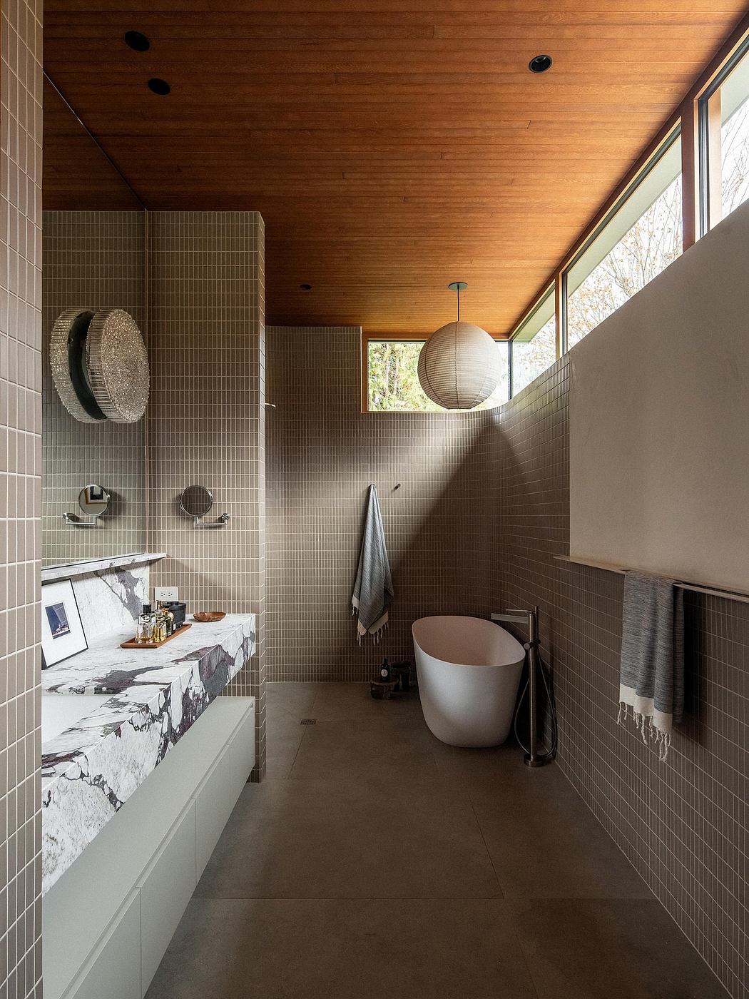 Sleek, modern bathroom with geometric tiles, floating vanity, and freestanding tub.