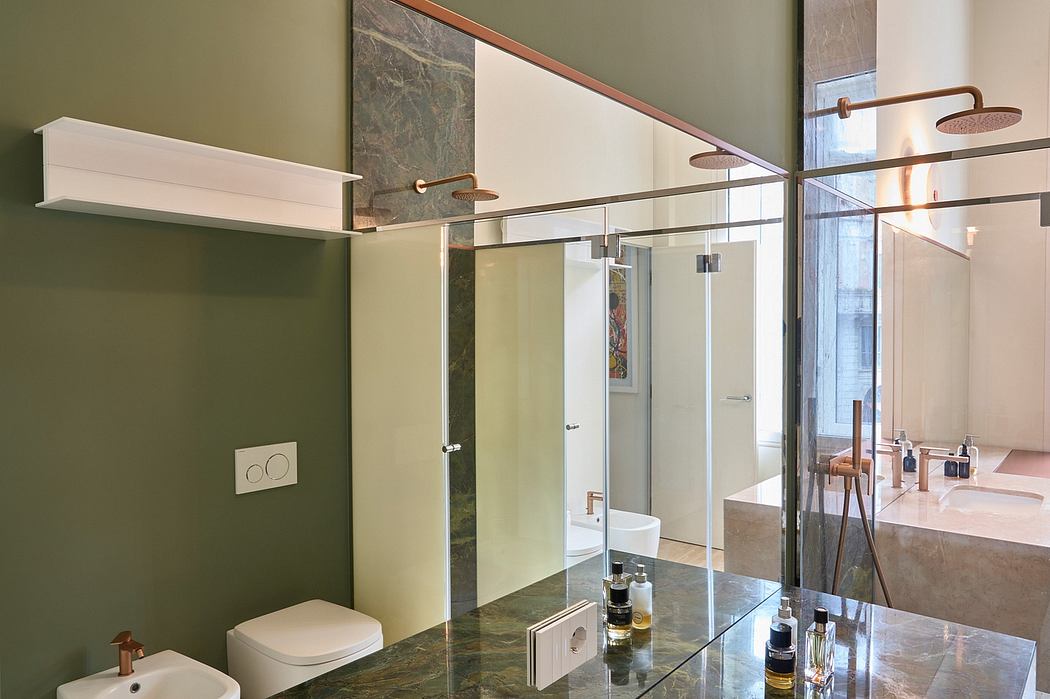 Spacious bathroom with glass walls, marble tiles, and contemporary brass fixtures.