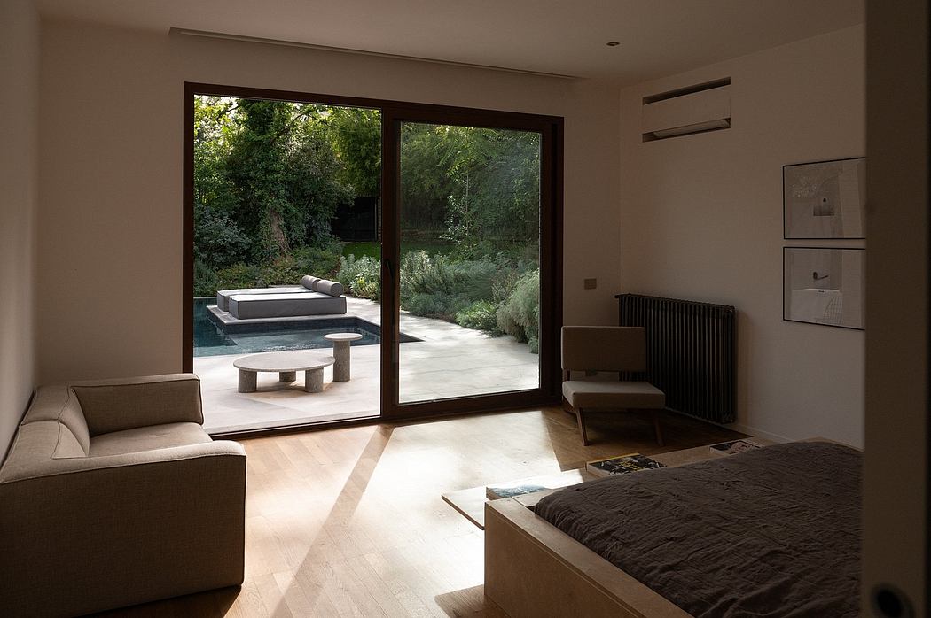 Bright, airy room with large windows overlooking lush garden and pool area. Minimalist decor.