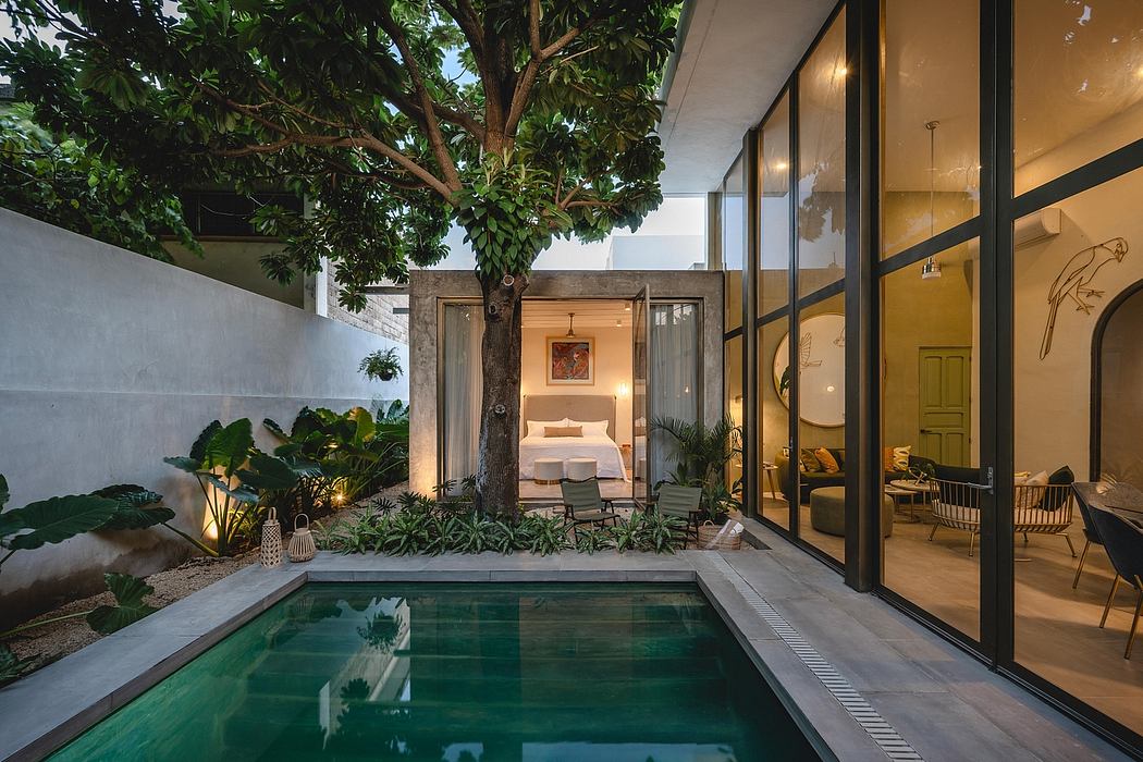 Lush tropical courtyard with a sleek pool, surrounded by glass walls and nature.