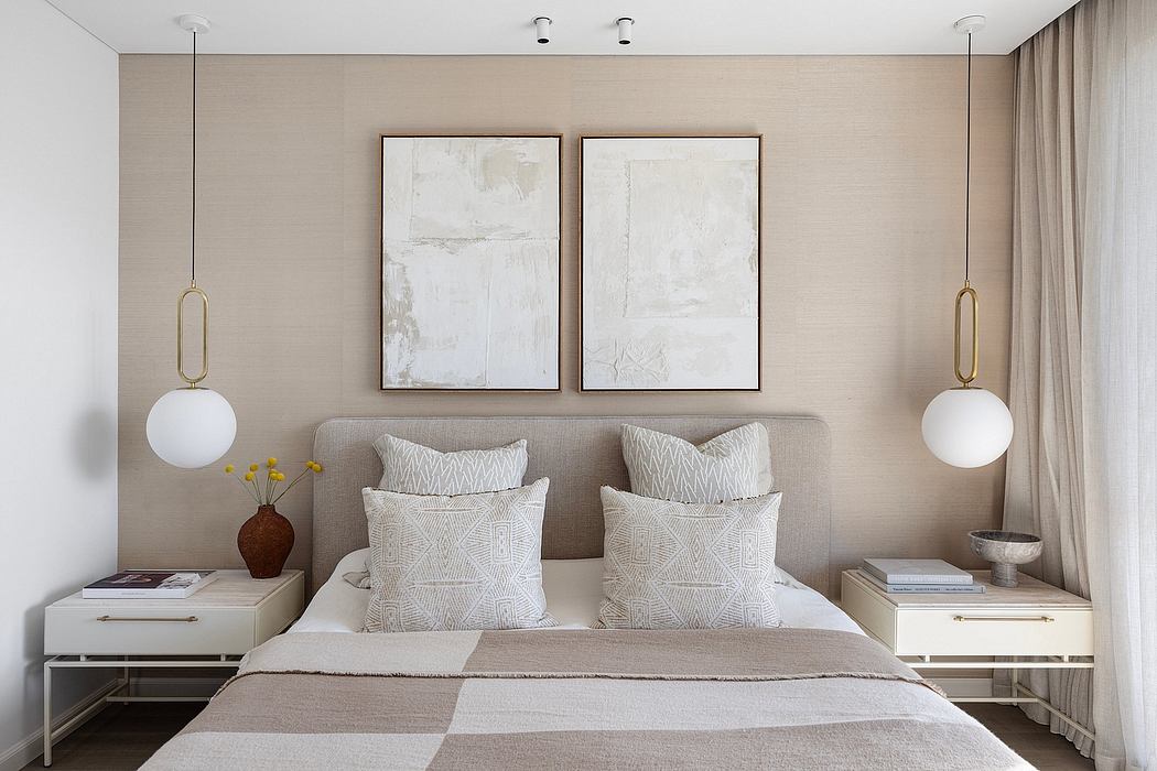 Minimalist bedroom with beige walls, framed abstract art, and coordinated bedding.