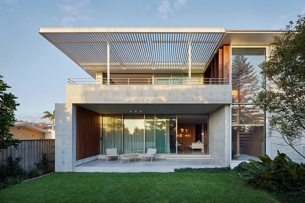 Modern beach house with open-concept design, clean lines, and a covered terrace.