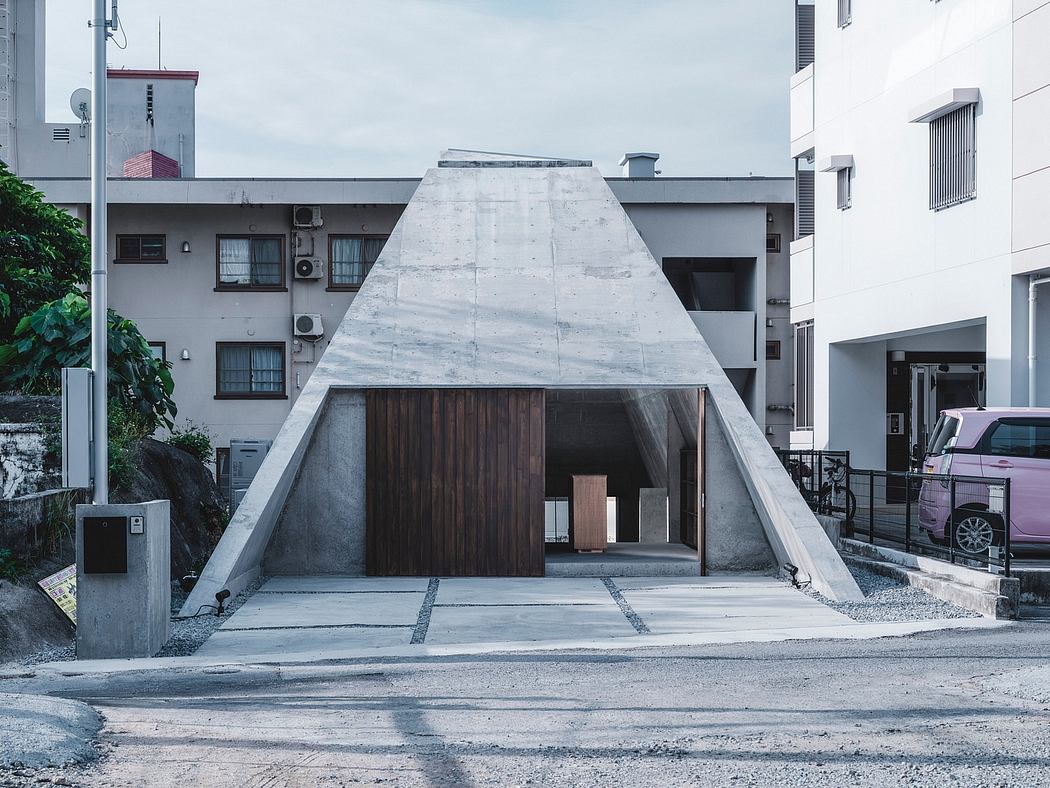 Striking concrete and wood structure with a distinctive triangular shape and recessed entrance.