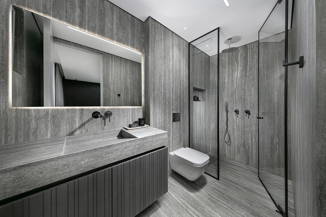 A modern bathroom with sleek gray tiles, a floating vanity, and a large frameless mirror.
