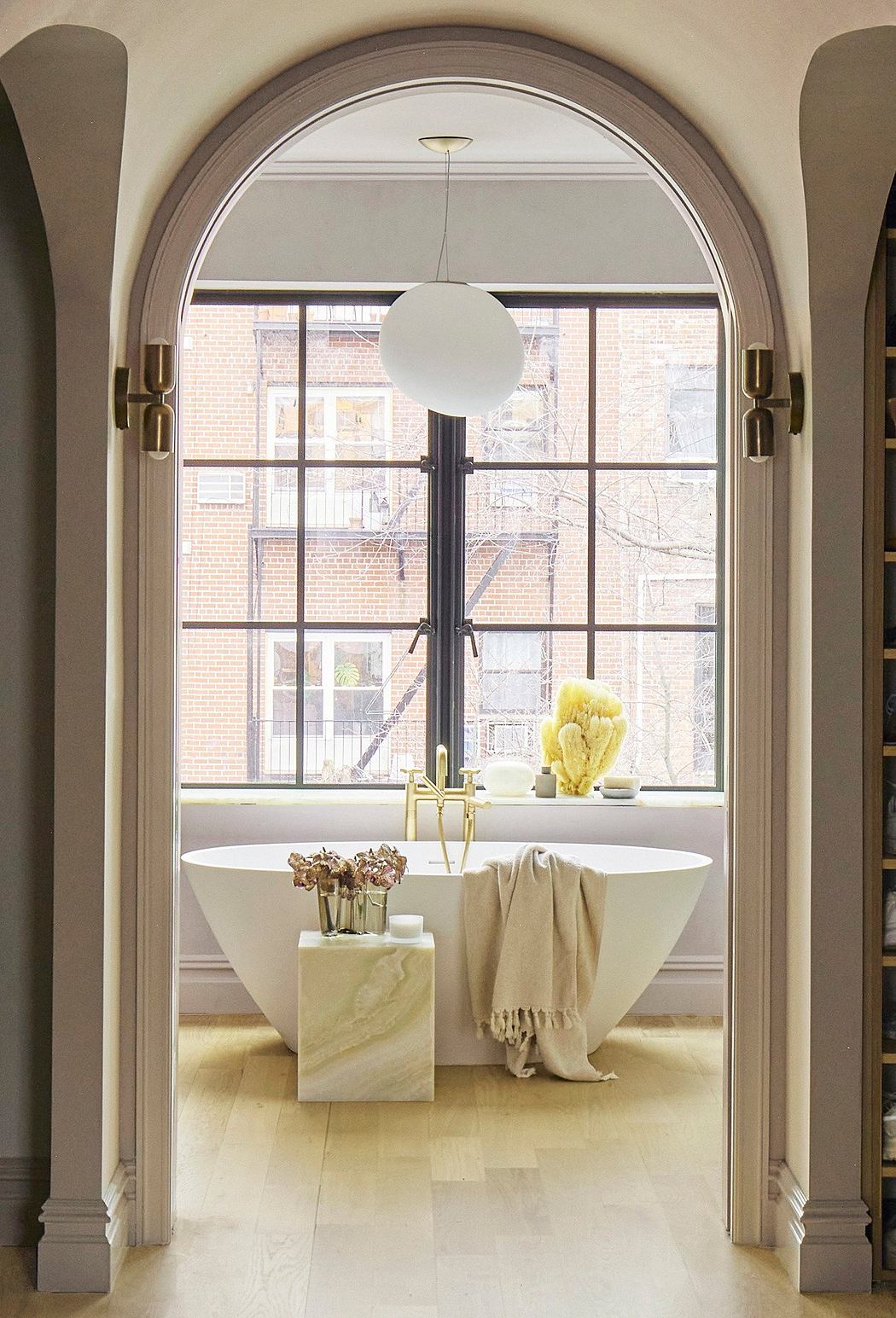 Arched window frames, freestanding bathtub, and decorative elements in a luxurious bathroom.