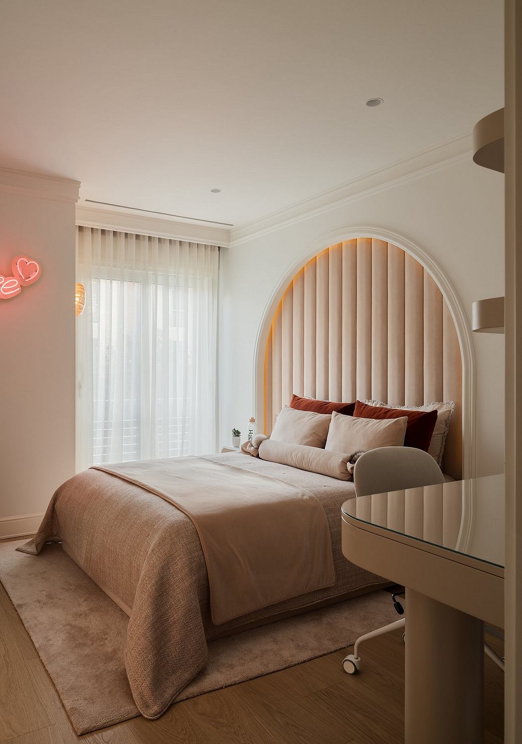 Cozy bedroom with arched, backlit headboard, neutral tones, and modern furnishings.
