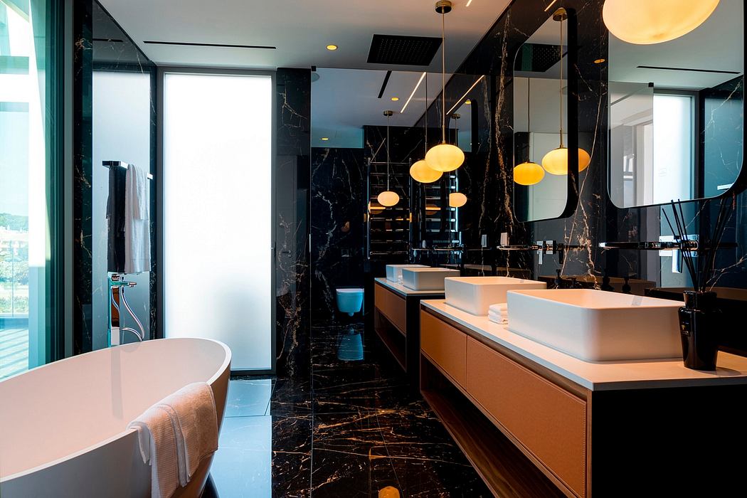 Luxurious bathroom with sleek black marble, modern vanity, and warm pendant lights.