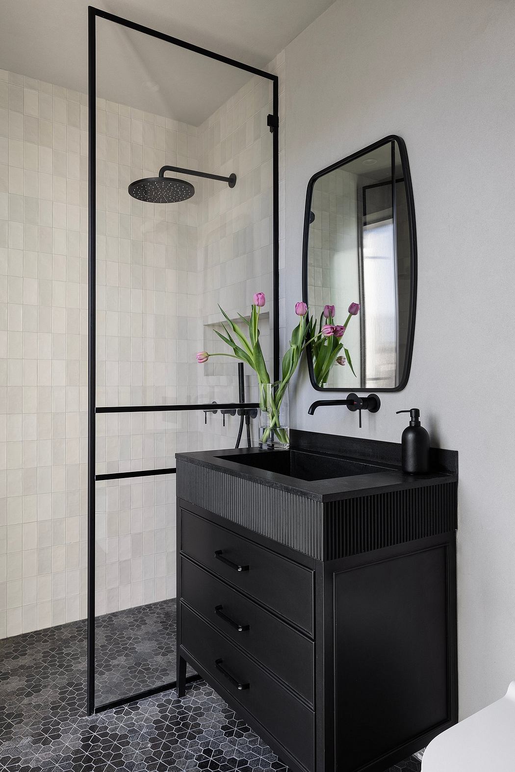Sleek black and white bathroom with a modern vanity, mirror, and rainfall shower.