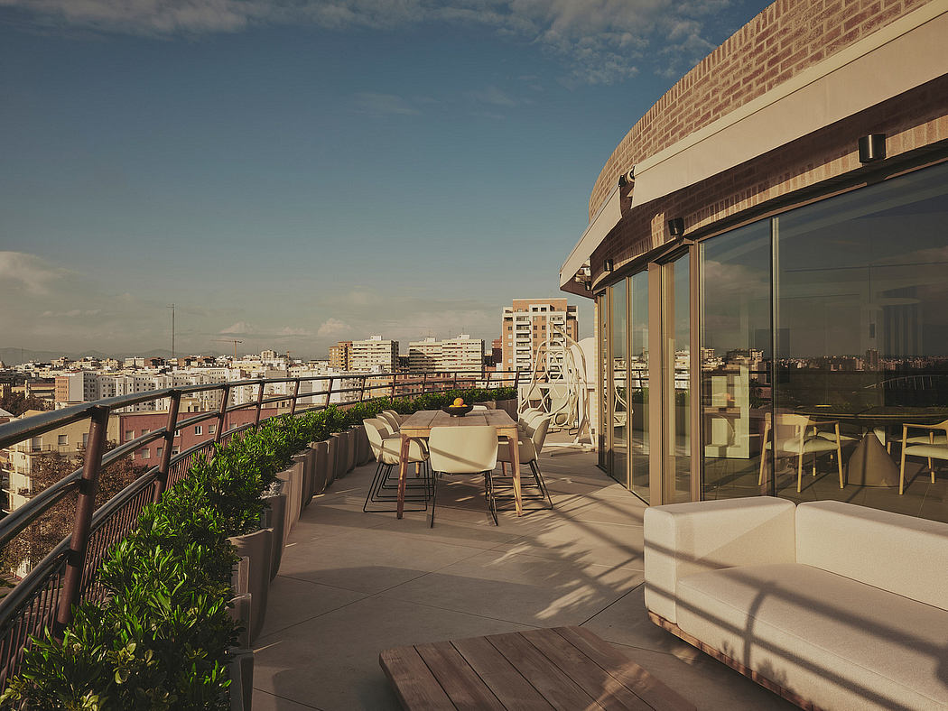A high-end urban rooftop terrace with modern furniture, glass walls, and cityscape view.