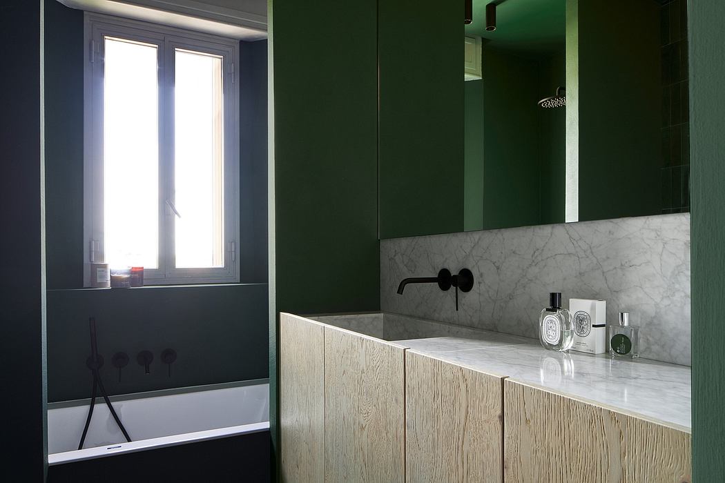 Elegant bathroom design with dark green walls, marble countertop, and wooden cabinets.