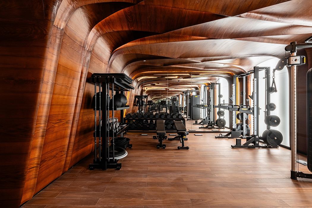 Expansive wooden fitness facility with curved ceiling, modern equipment, and warm tones.