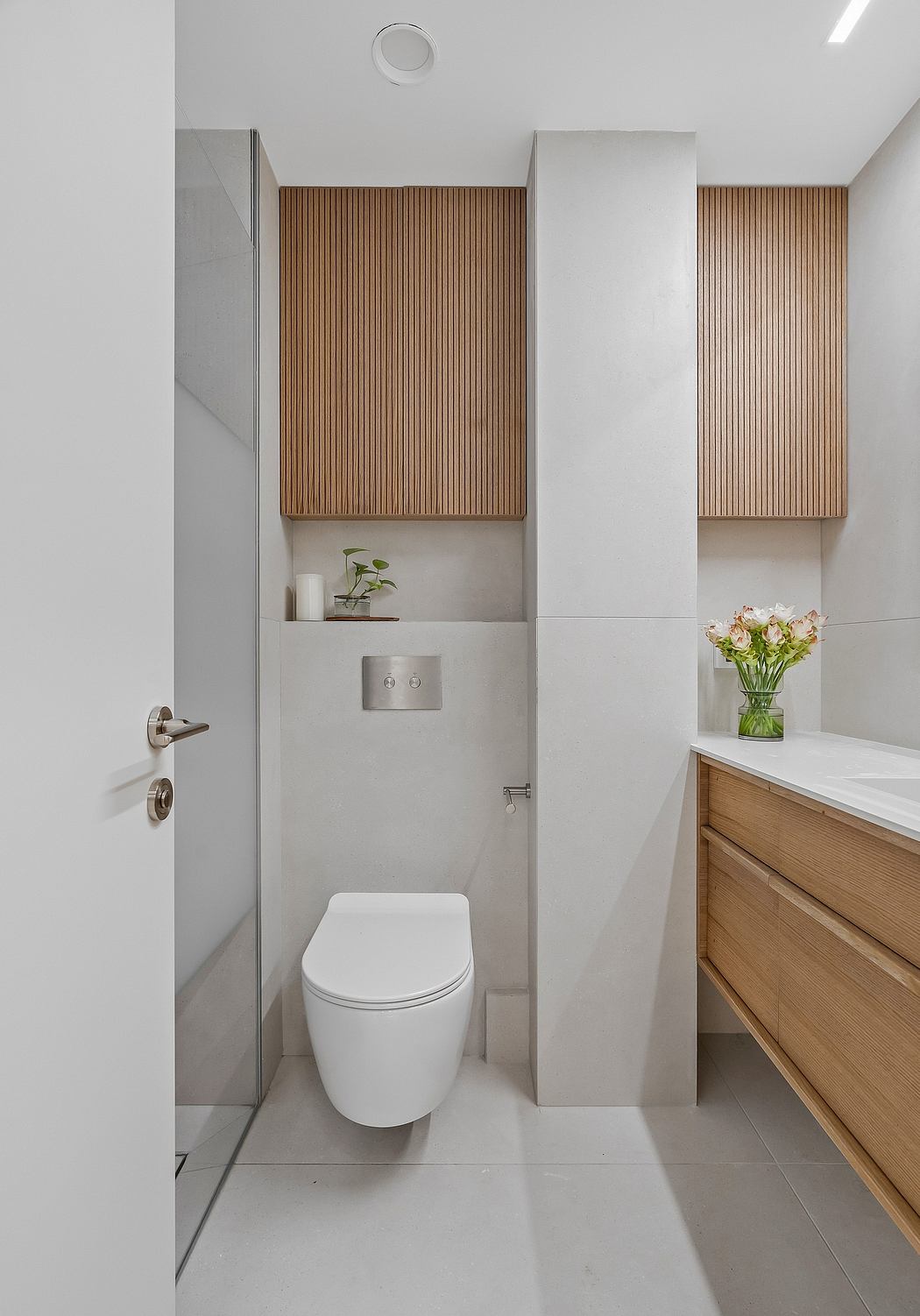 Minimalist bathroom design with wood-paneled wall features, built-in shelving, and a modern vanity.