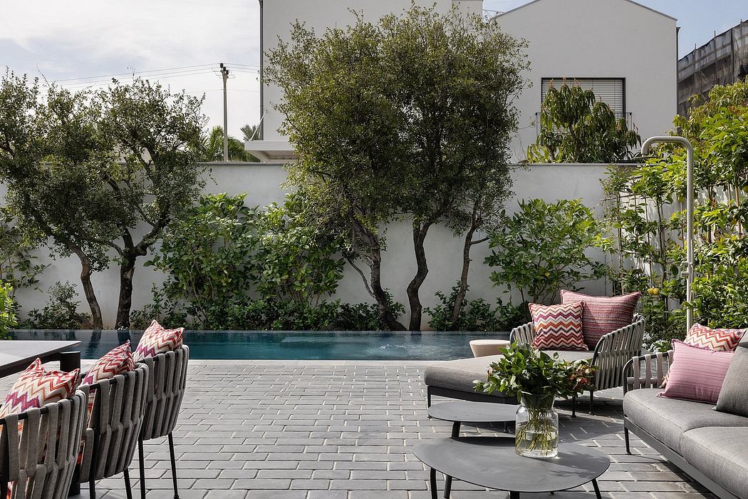 Sleek outdoor living space with minimalist furniture, lush greenery, and a stylish pool.