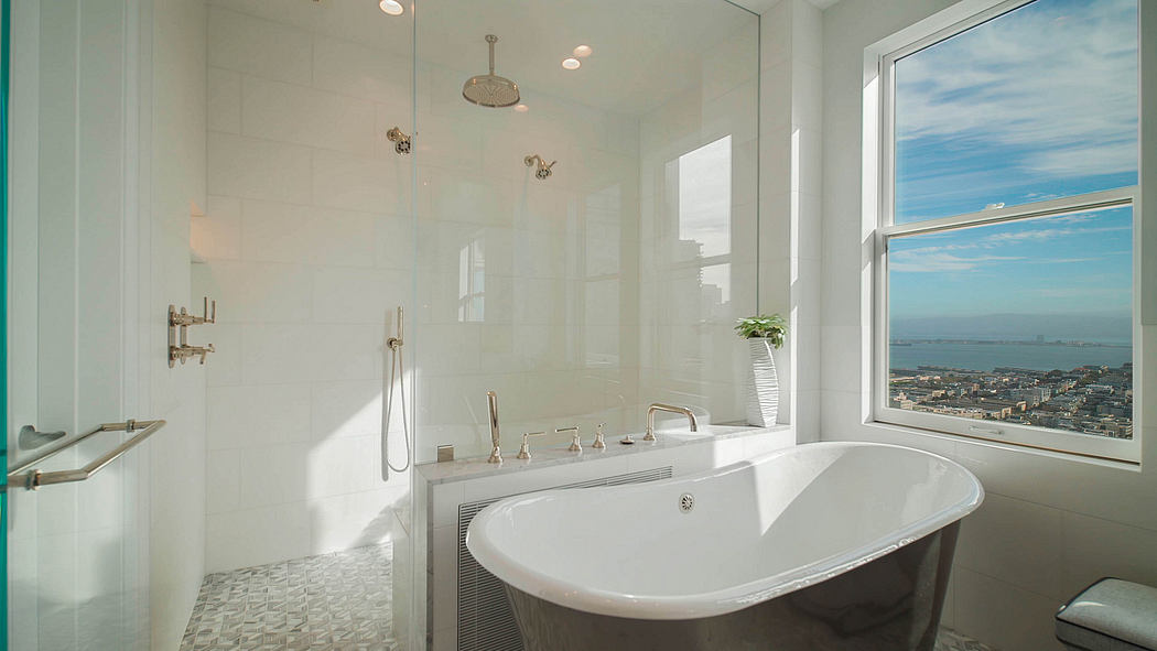 Luxurious bathroom with freestanding tub, shower, and stunning city view.