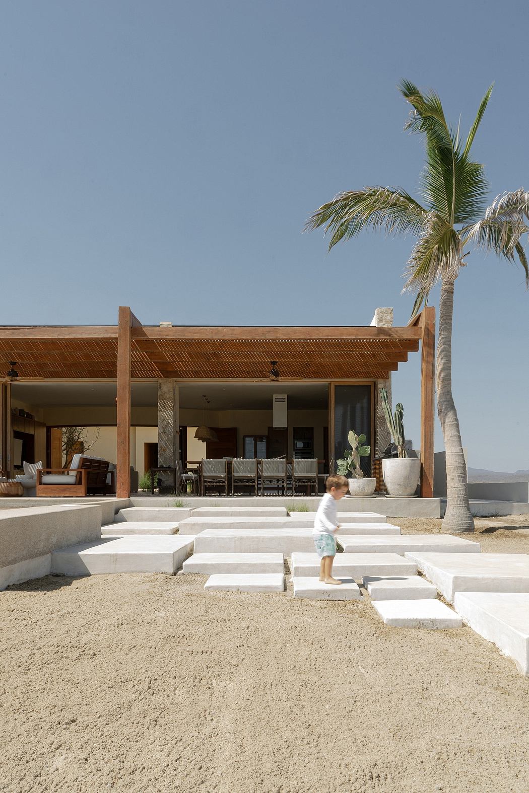 Expansive beachfront vacation home with a contemporary tropical design and a playful stepped terrace.