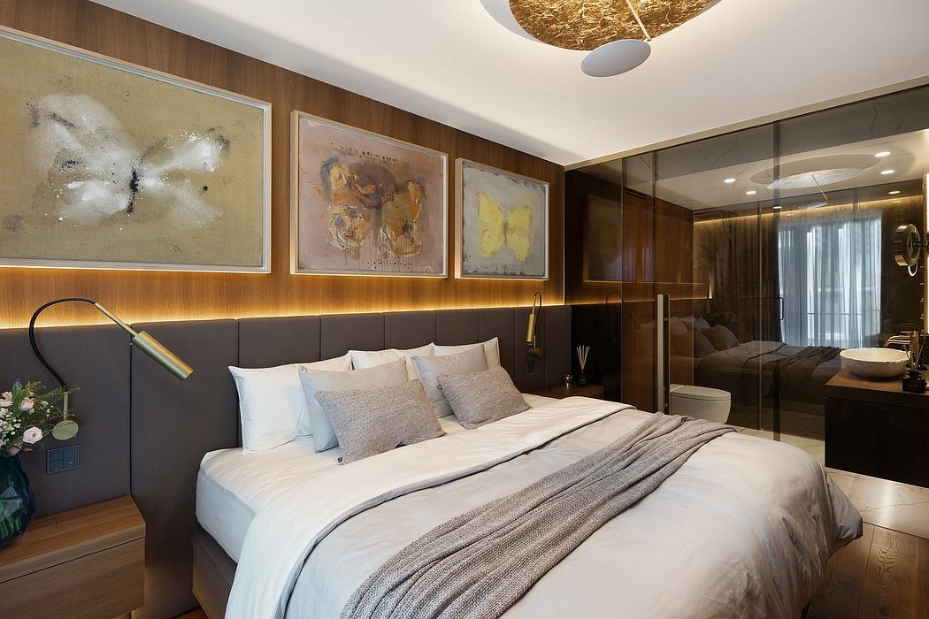 A modern, luxurious bedroom with a plush bed, abstract artwork, and a striking golden light fixture.