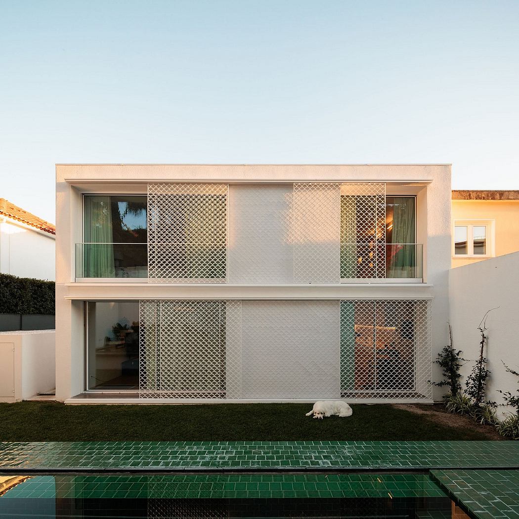 A modern two-story house with a distinctive pattern of metal screens covering the facade.