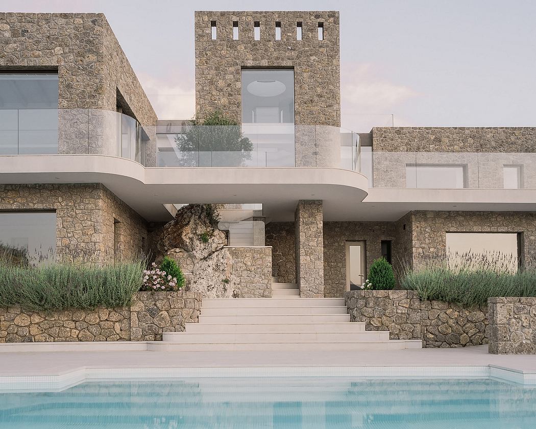 Striking modern stone architecture with pool, stepped terrace, and natural landscaping.