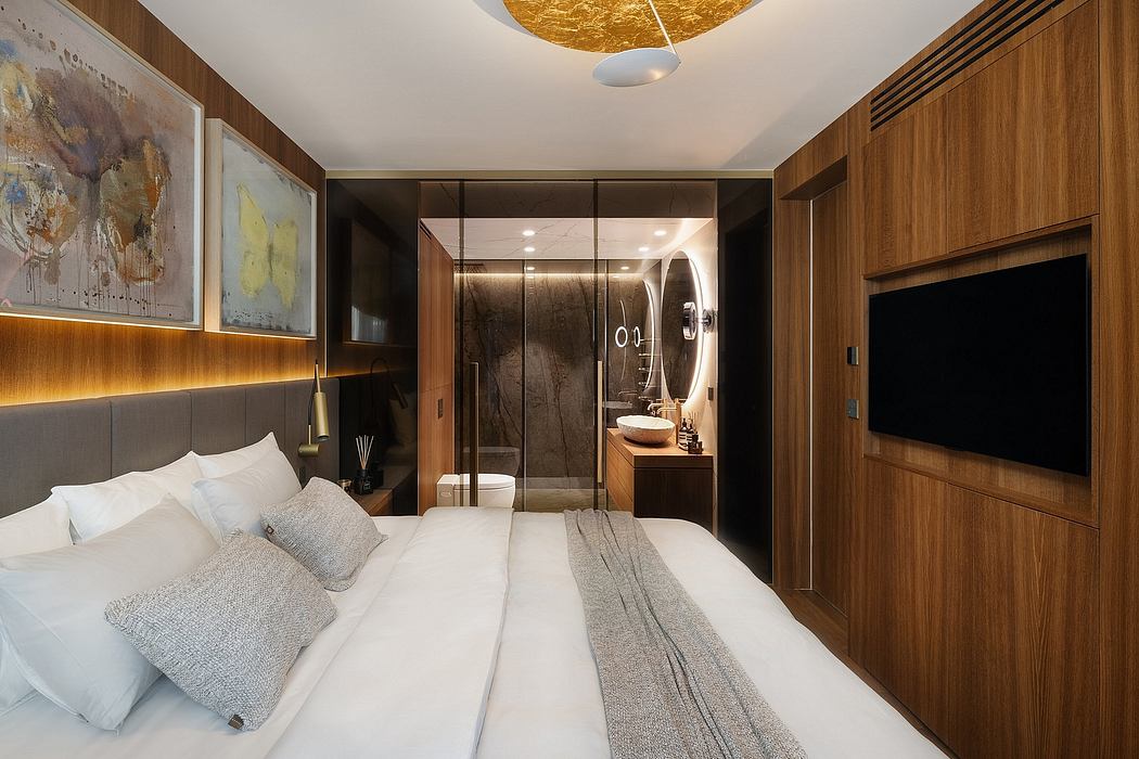 Elegant modern bedroom with glass-enclosed bathroom, wood and stone accents.