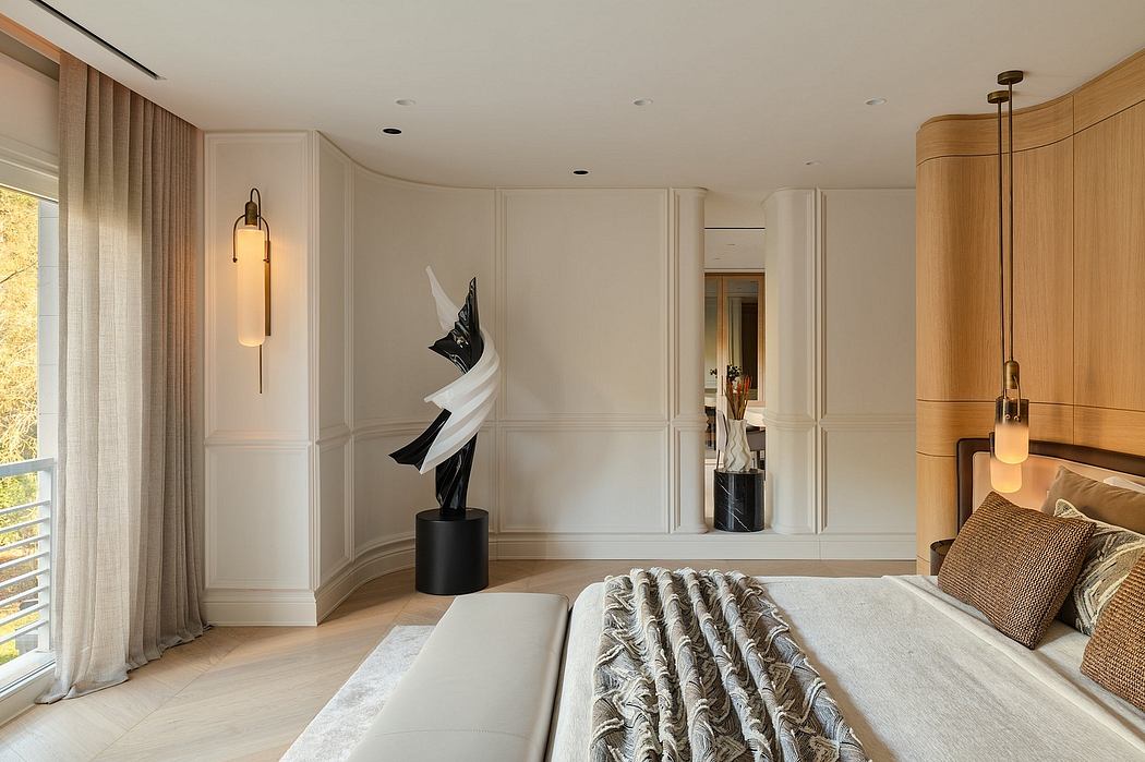 Elegant bedroom with modern architectural details, plush furnishings, and sculptural artwork.