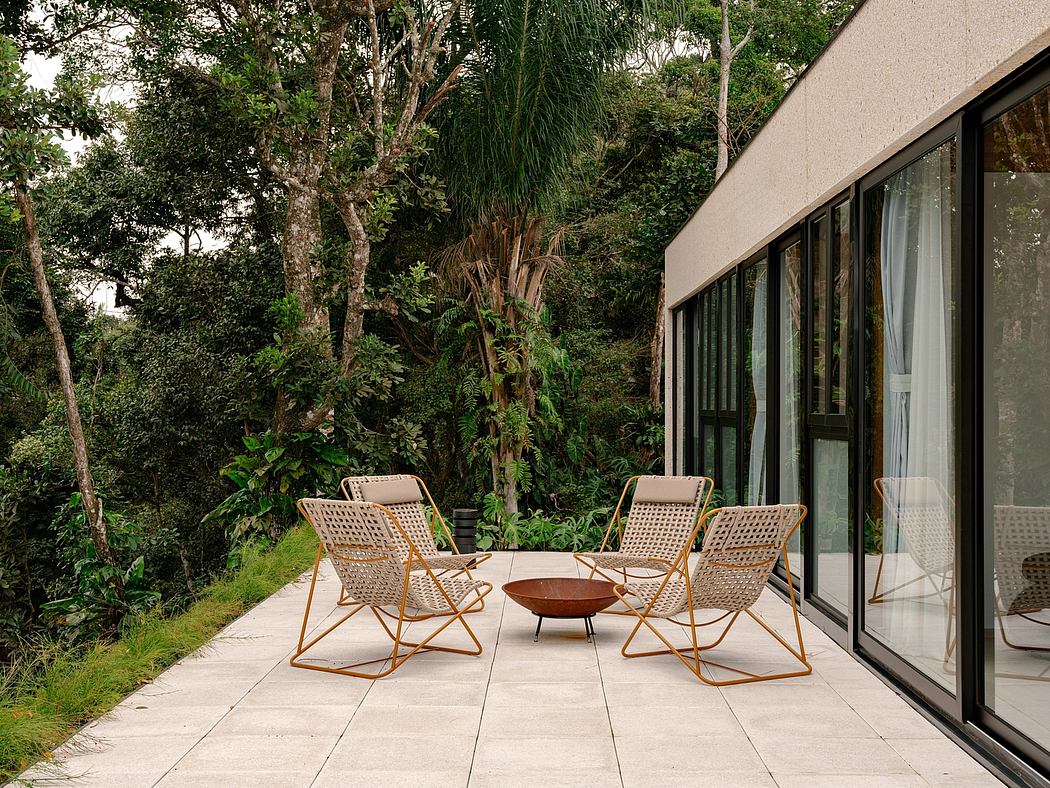 Tranquil outdoor seating area surrounded by lush greenery and glass walls.