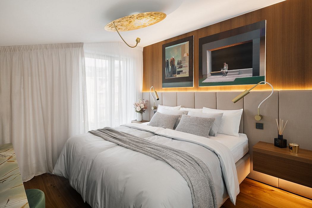 Modern bedroom with plush bedding, warm lighting, and striking artwork on the walls.