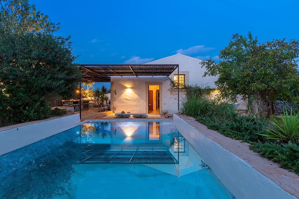 Inviting open-air oasis with pool and covered terrace, surrounded by lush greenery.