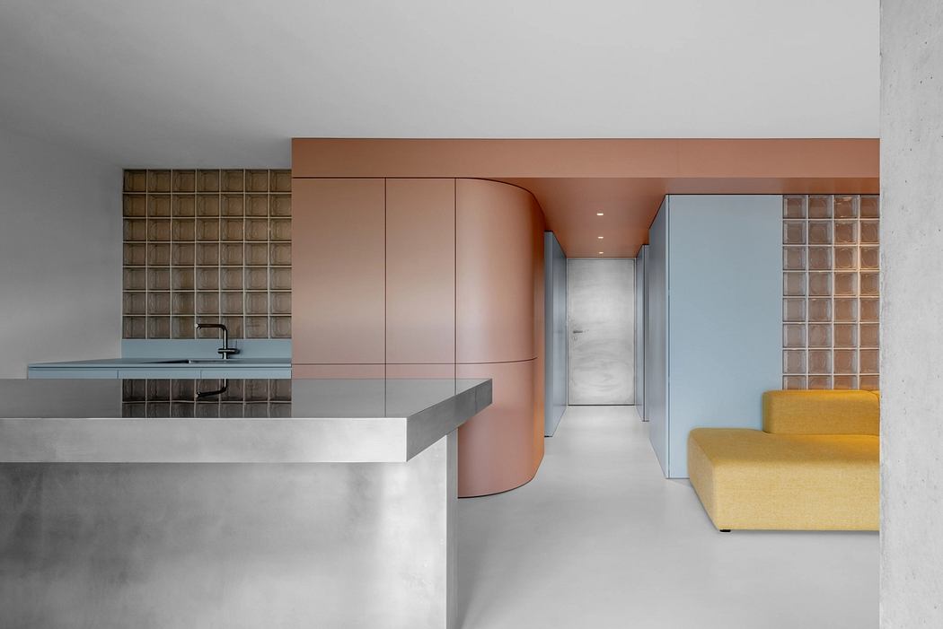 Minimalist interior design featuring curved pink accent wall, glass block tiles, and sleek gray countertop.