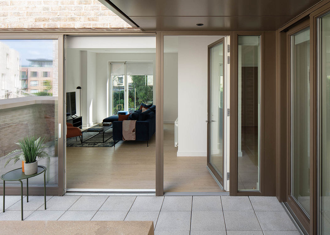 Spacious modern apartment with large windows, sliding glass doors, and minimalist decor.