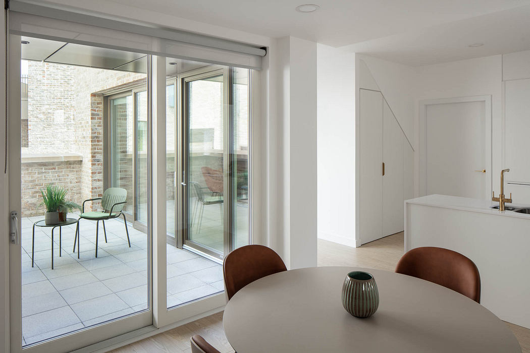 Bright, minimalist dining area with large sliding glass doors leading to a balcony.