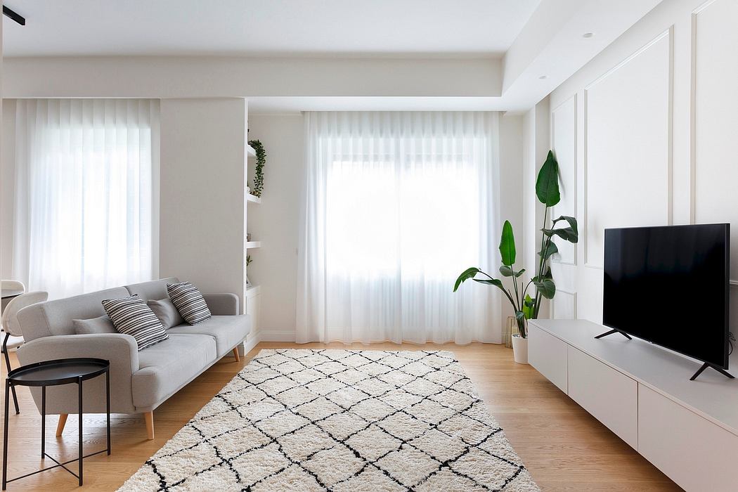 Bright, minimalist living room with large windows, sleek furniture, and decorative plant.