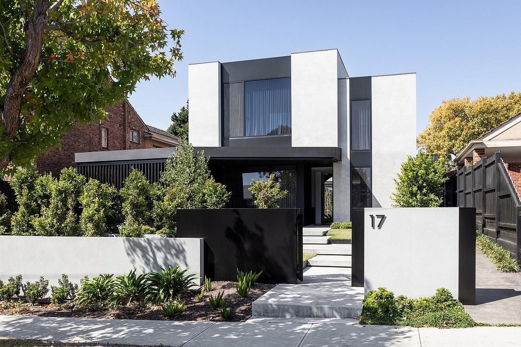 Modern, angular architecture with sleek black and white exterior, featuring a recessed entryway.
