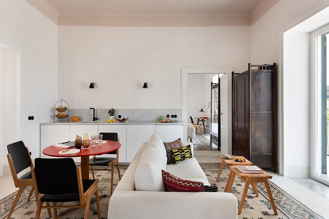 Bright open-plan living area with white walls, modern furniture, and patterned tiles.