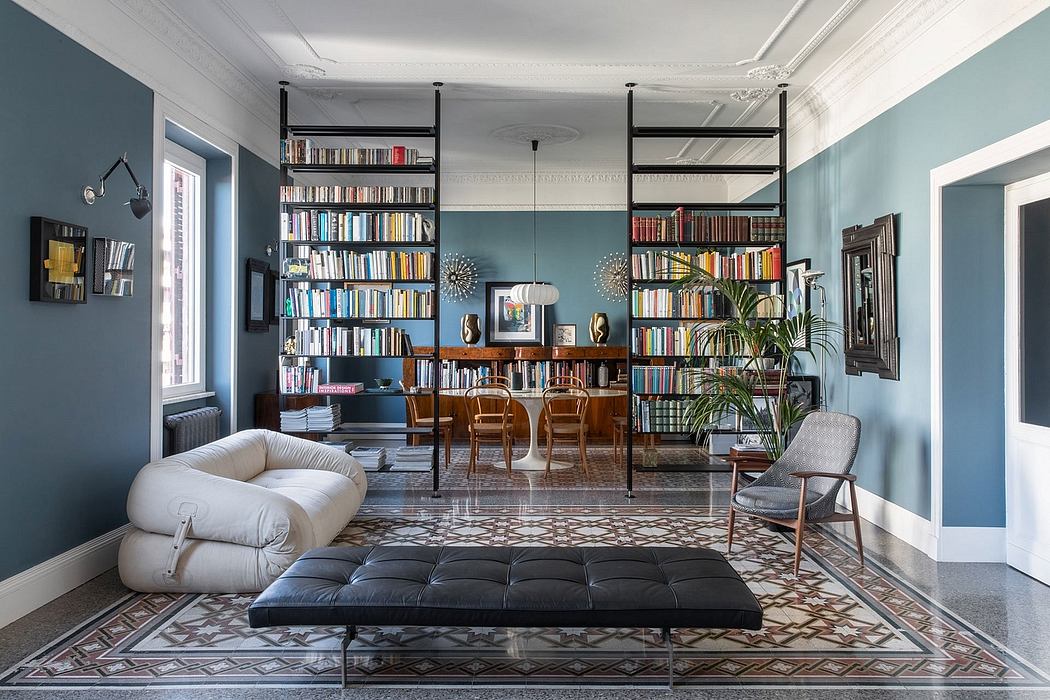 Spacious living room with vibrant blue walls, built-in bookshelves, and an ornate tiled floor.