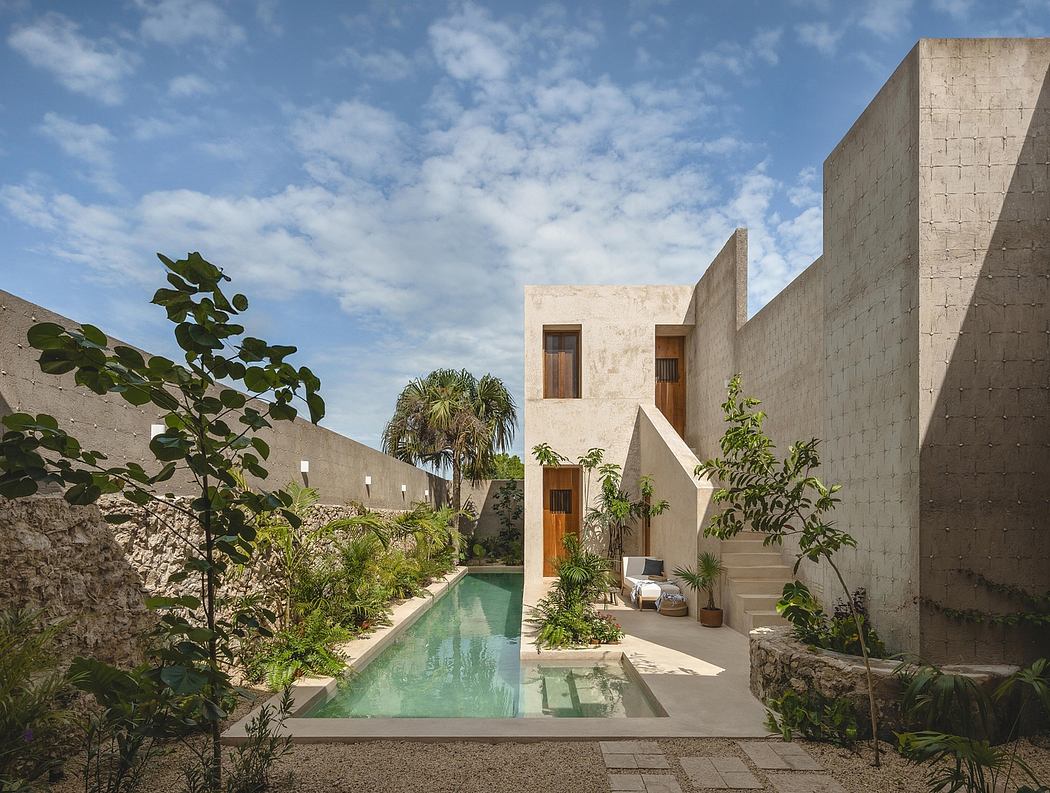 A modern, open-concept courtyard with a rectangular pool, lush vegetation, and geometric architecture.