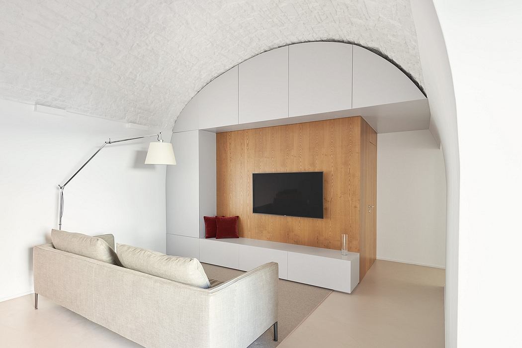 Minimalist living room with arched ceiling, wooden TV panel, and modern furniture.