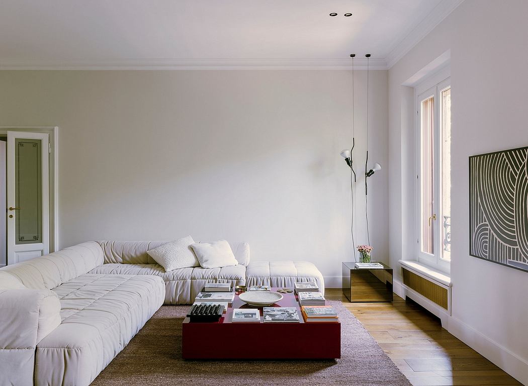 Spacious living room with minimalist furniture, neutral color palette, and modern lighting.