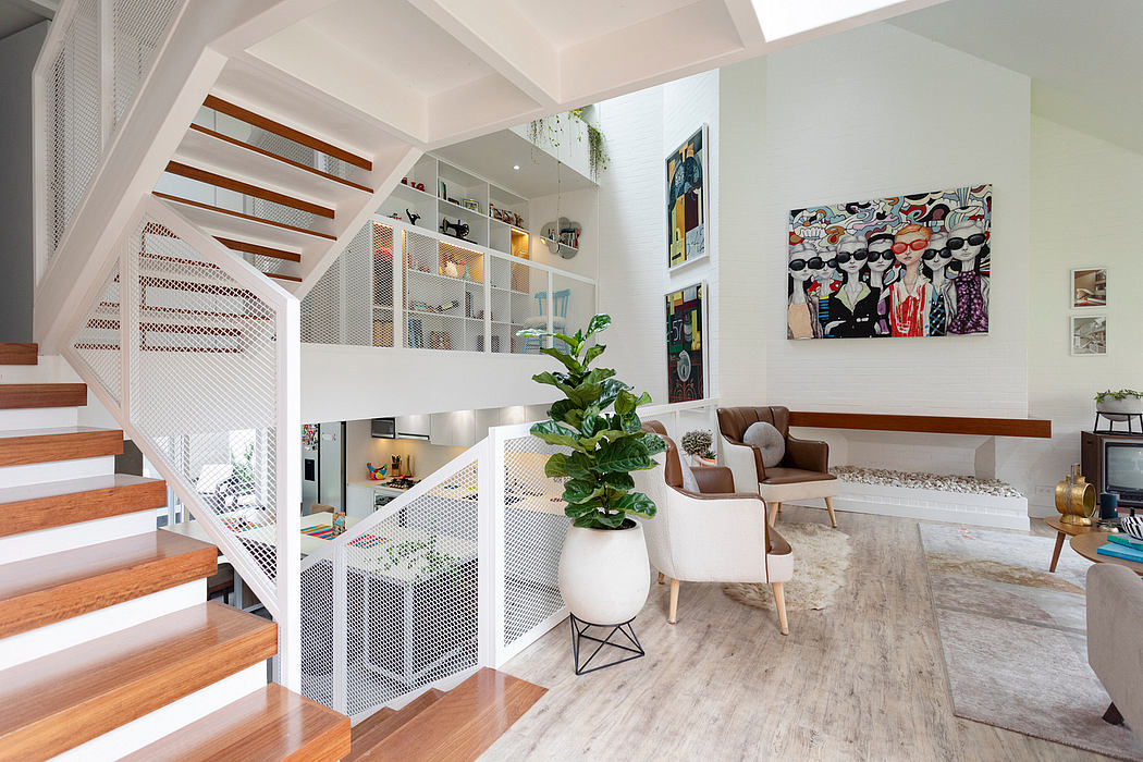 Modern, open-concept living space with wooden stairs, built-in shelves, and vibrant artwork.