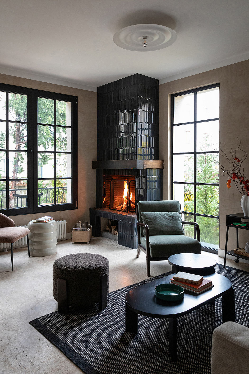 Spacious living room with large fireplace, modern furnishings, and floor-to-ceiling windows.