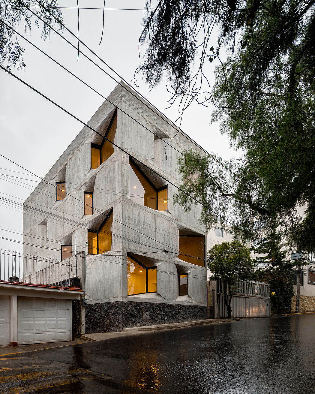 A multi-level concrete structure with striking geometric patterns and illuminated windows.